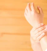 Person holding wrist pain area, demonstrating arthritis discomfort.