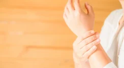 Person holding wrist pain area, demonstrating arthritis discomfort.