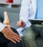 Pain doctor helping patient with knee pain