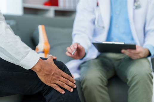 Pain doctor helping patient with knee pain
